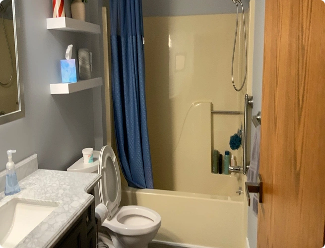 Small, cramped bathroom with a high tub wall