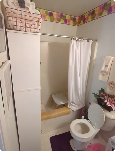Small, cramped bathroom with a high tub wall